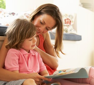 Mother Sitting With Son Reading Story Indoors