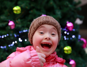 girl with winter cloths by christmas tree