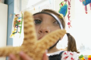 girl looking at starfish with magnifying glass