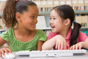 two girls on computer keyboard