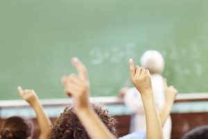 diverse hands raised classroom