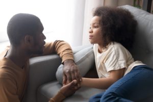 father talking to daughter and reassuring her